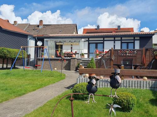 a house with two birds sitting on a bench at Ferienhaus Müller in Benneckenstein