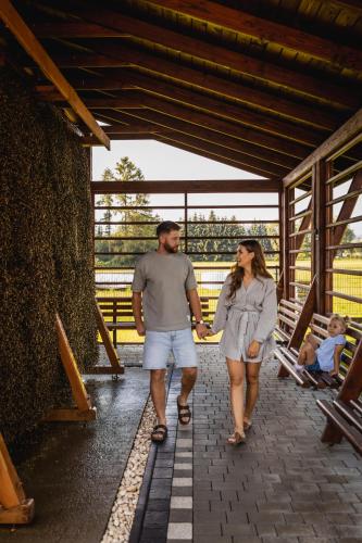 a man and a woman walking down a walkway at Apartamenty, pokoje PRZY TERMACH - 70 m Termy Szaflary, 150 m Gorący Potok in Szaflary