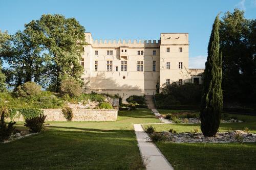 un grand château blanc avec un jardin et des arbres dans l'établissement Château de Pondres, à Villevieille