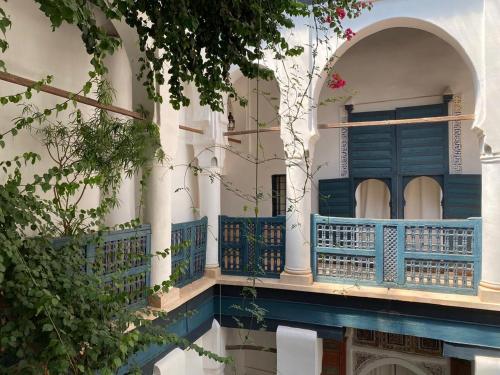 a building with a blue balcony and a tree at Dar El Qadi in Marrakech