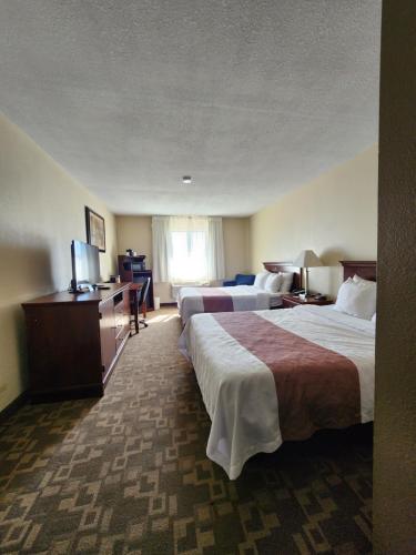 a hotel room with two beds and a flat screen tv at Quality Inn I-70 at Wanamaker in Topeka