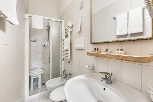 a white bathroom with a sink and a toilet at Hotel Marconi in Venice