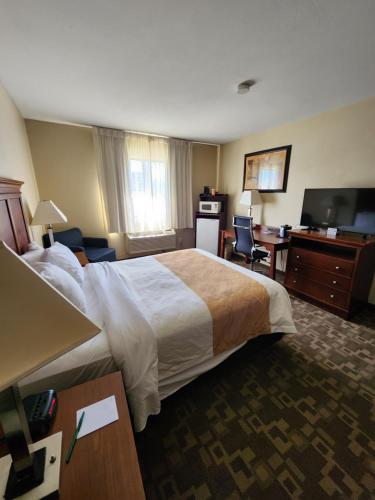 a hotel room with a large bed and a desk at Quality Inn I-70 at Wanamaker in Topeka