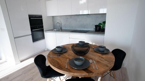 Una cocina con una mesa de madera y sillas negras. en Downtown28 apartment, en Poprad