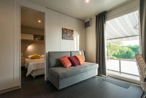een kamer met een bank, een bed en een raam bij Holiday Home Trend in Donji Zagon