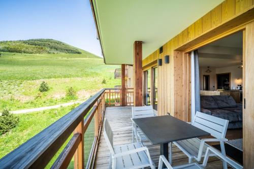 a wooden balcony with a table and chairs on it at Residence Hameau de Clotaire Alpe d'Huez - by EMERALD STAY in L'Alpe-d'Huez