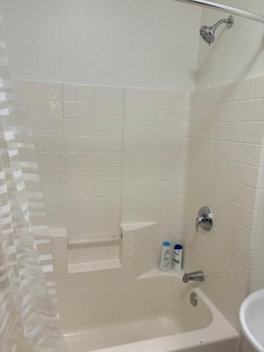 a white bathroom with a tub and a sink at Downtown Portland Cozy Studio in Portland