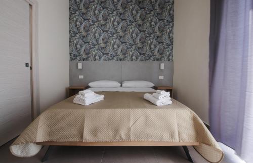 a bedroom with a bed with two towels on it at Dimora Savoia in Naples