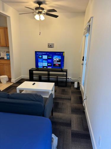 a living room with a blue couch and a flat screen tv at Downtown Portland Cozy Studio in Portland