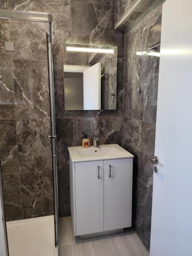 a bathroom with a white sink and a shower at Marina view seaside apartment in Larnaka