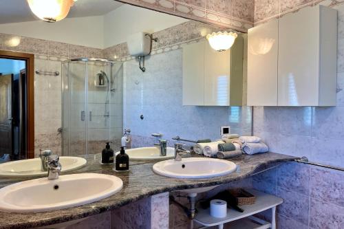 a bathroom with two sinks and a shower at Luxury Home Cabras Centro in Càbras
