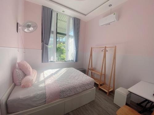 a small bedroom with a bed and a window at Naomi House Phan Thiet in Phan Thiet
