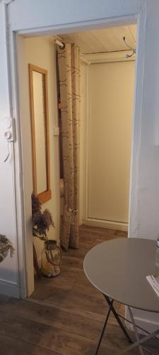 - un couloir avec une table et une porte dans une chambre dans l'établissement Chambre indépendante chez l'habitant avec salle de bain privée, à Aleçon