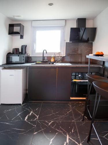 une cuisine avec un comptoir, un évier et une fenêtre dans l'établissement Cinéma Privé-Compiègne - Sitivia, à Margny-lès-Compiègne