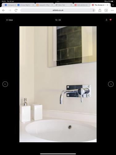 a bathroom sink with a faucet and a mirror at The Annex is in the beautiful Ashdown Forest in Crowborough