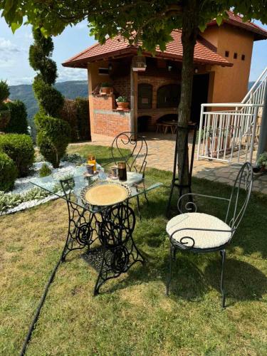 a table and chairs sitting in the grass in front of a house at Etno selo Milanovic - Nonac in Kuršumlija