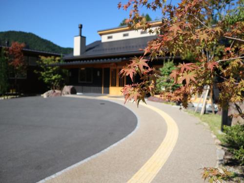 a road in front of a building with a building at はなぞの温泉 花圃の里 in Oshite