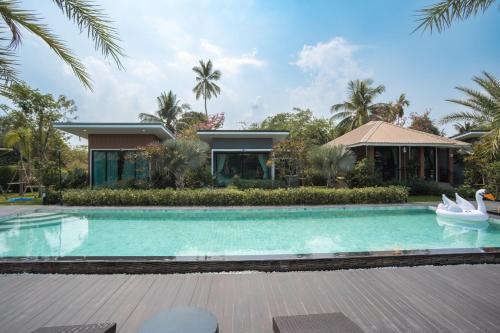 a swimming pool in front of a house at SeeView Resort (ซีวิว รีสอร์ต) in Ban Pak Nam