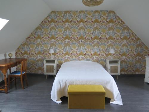 a bedroom with a bed and a piano and a table at La blanche hermine in Yvias