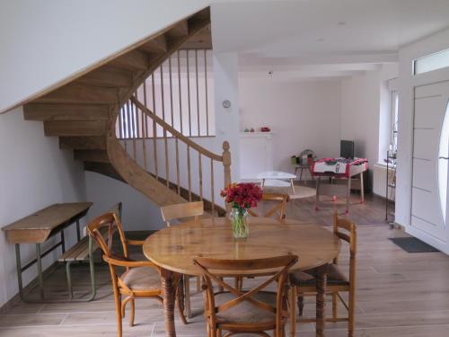 une salle à manger avec une table et un escalier dans l'établissement La blanche hermine, à Yvias