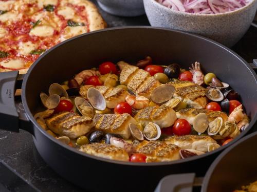 a pan of food with seafood and a pizza at Novotel Nara in Nara
