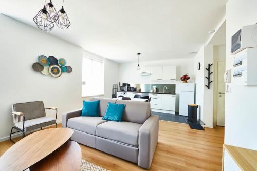un salon avec un canapé et une cuisine dans l'établissement BM-1 Appartement au 1er étage - F2 - 1 à 4 pers, à Mulhouse