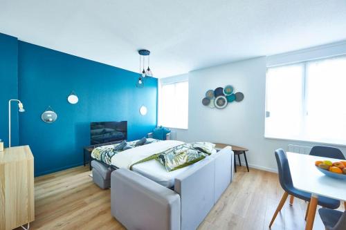 - une chambre bleue avec un lit et une table dans l'établissement BM-1 Appartement au 1er étage - F2 - 1 à 4 pers, à Mulhouse
