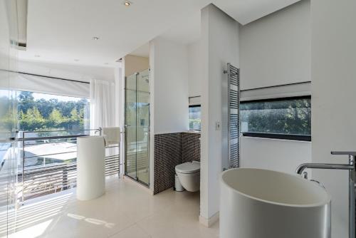 Elle comprend un balcon et une salle de bains blanche pourvue de toilettes. dans l'établissement Villa IRIS, à Ramatuelle