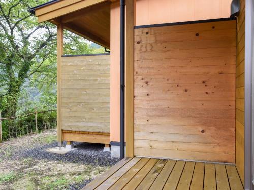 a wooden pergola on the side of a building at はなぞの温泉 花圃の里 in Oshite