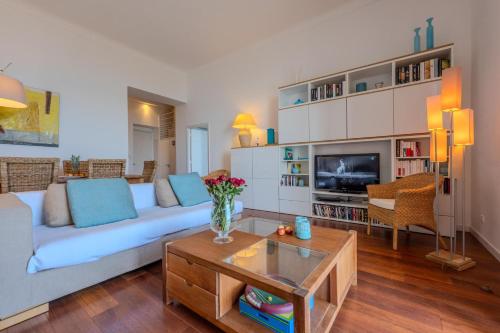 un salon avec un canapé et une télévision dans l'établissement Cap Martin, à Roquebrune-Cap-Martin