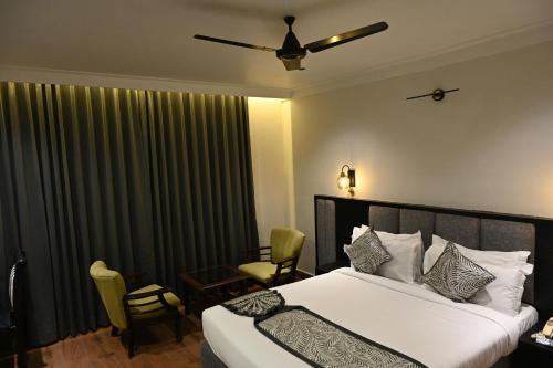 a bedroom with a bed and a window with curtains at The Budhil Park in Visakhapatnam