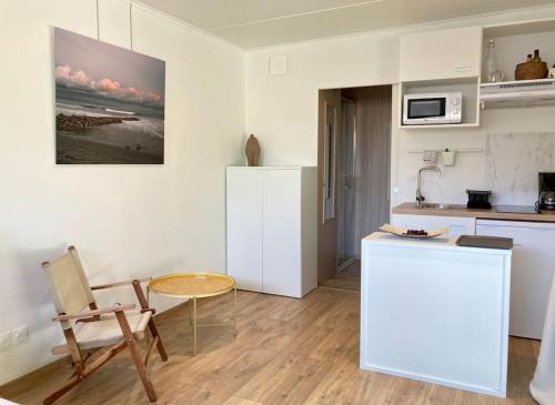 une cuisine avec un comptoir, une table et une chaise dans l'établissement Tiny House Montpellier avec terrasse, à Montpellier