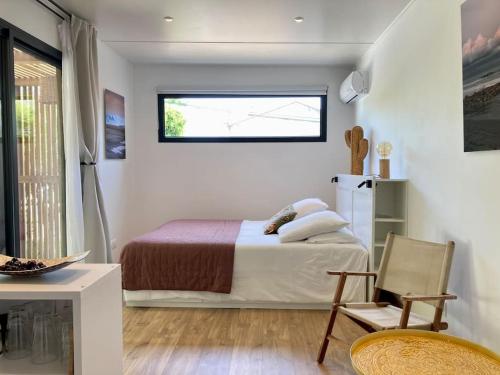 une chambre avec un lit, une fenêtre et une chaise dans l'établissement Tiny House Montpellier avec terrasse, à Montpellier