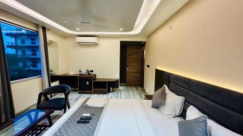 a room with a bed and a desk and a chair at Raksha Suites & Banquet Greater Noida in Greater Noida