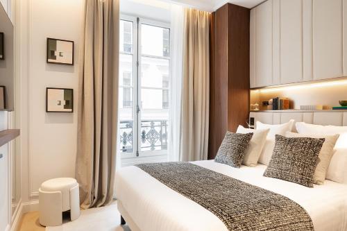 une chambre avec un lit et une grande fenêtre dans l'établissement TheLander - Serviced Apartments in Opéra, à Paris