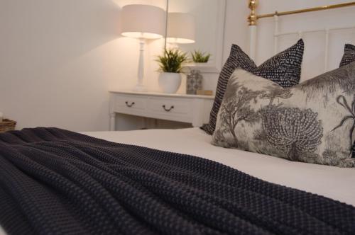a bedroom with a bed with black and white pillows at Killassy House in Graaff-Reinet