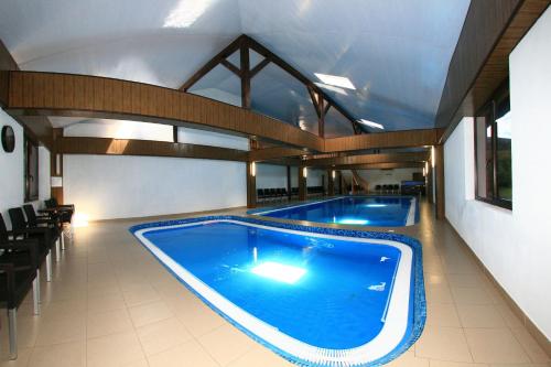 a large swimming pool in a large building at Pensiunea Mario & Ema in Cîrlibaba