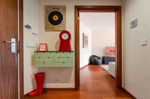a hallway with red boots and a wall with a mirror at GuestReady - Teddy Jazz in Porto