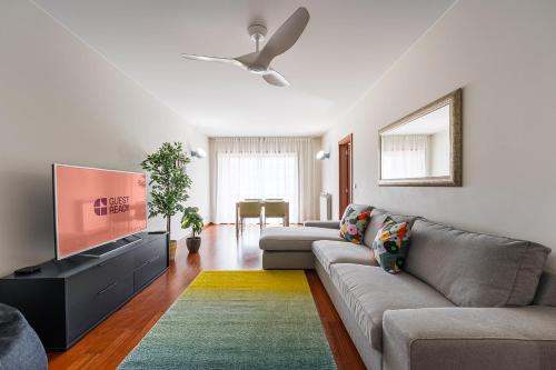 a living room with a couch and a flat screen tv at GuestReady - Teddy Jazz in Porto