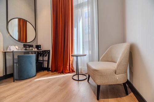 a living room with a chair and a mirror at Soho Boutique Turia in Valencia