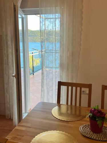 a dining room table with a view of the ocean at Seacoast apartments MELIHA in Neum