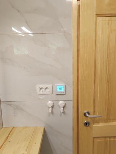 a bathroom with white marble walls and a wooden door at Honey house in Zgornje Gorje