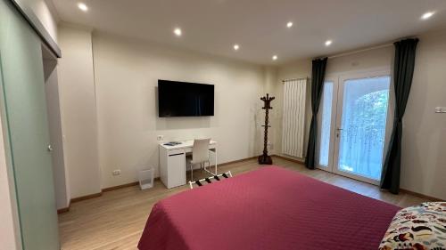 a bedroom with a bed and a desk and a tv at B&B La Giganta in Porto Viro
