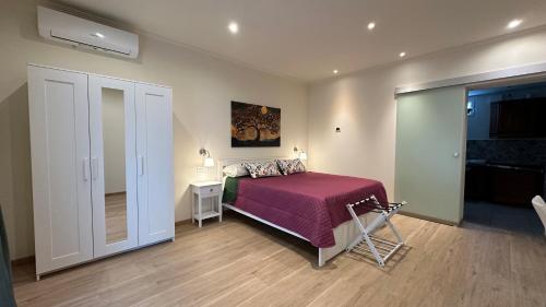 a bedroom with a bed with a pink bedspread and a mirror at B&B La Giganta in Porto Viro