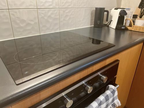 a kitchen counter with a stove top oven at A city oasis - full apartment with balcony in Perth