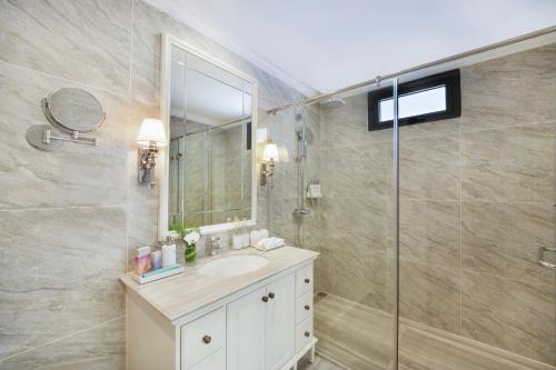 a bathroom with a sink and a shower with a mirror at Melia Vinpearl Phu Quoc in Phu Quoc