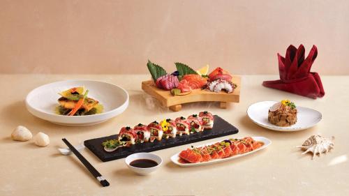 a table with plates of food and bowls of food at Melia Vinpearl Phu Quoc in Phu Quoc