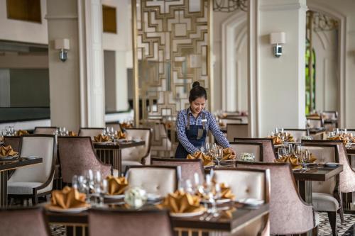 a woman standing at a table in a restaurant at Melia Vinpearl Phu Quoc in Phu Quoc