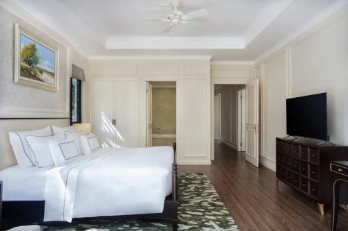 a bedroom with a white bed and a flat screen tv at Melia Vinpearl Phu Quoc in Phu Quoc