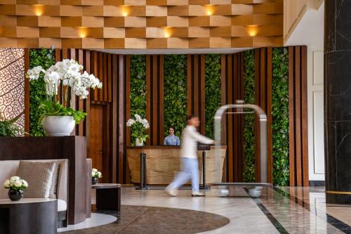 a man walking through a lobby with a green wall at Melia Vinpearl Phu Quoc in Phu Quoc